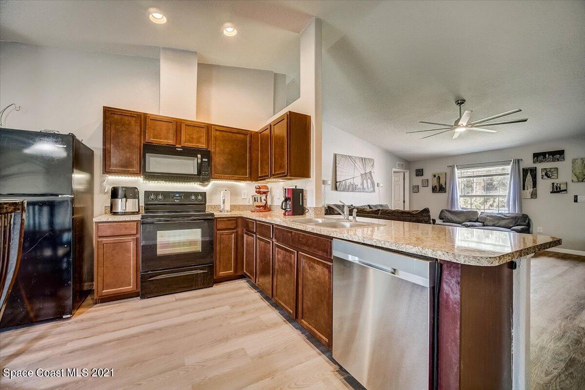 1459 Saxony Road Southwest Palm Bay, FL 32908 - Photo 10 of 38 a kitchen with stainless steel appliances a sink and a refrigerator