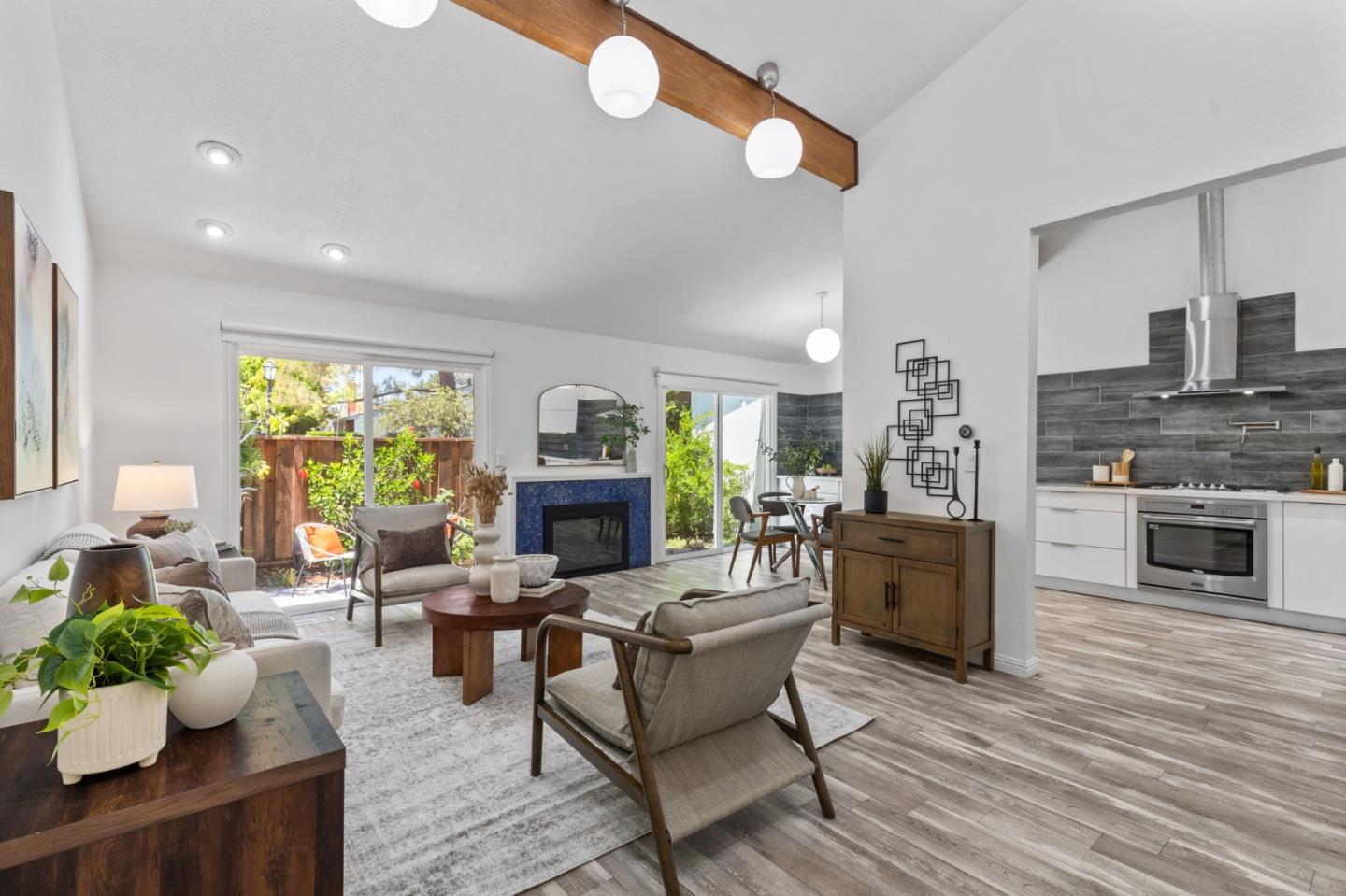 a living room with furniture a fireplace and a dining table with wooden floor