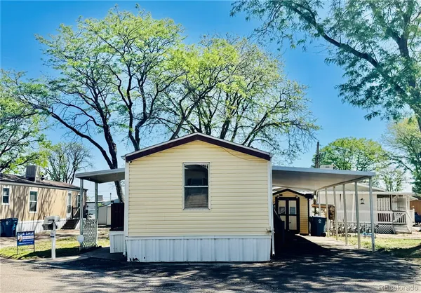 a view of a small house with yard and tree in the background