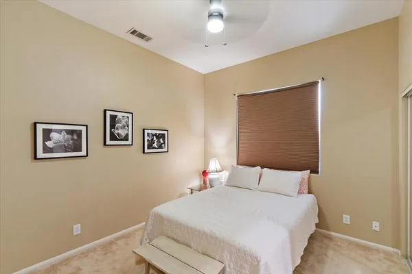 a bedroom with a bed and a painting on the wall