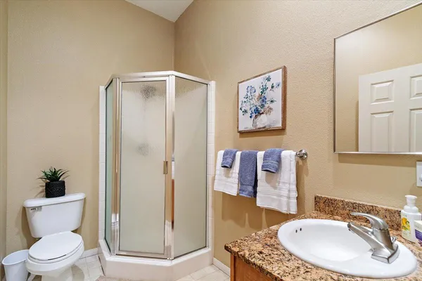 a bathroom with a granite countertop sink toilet and a mirror