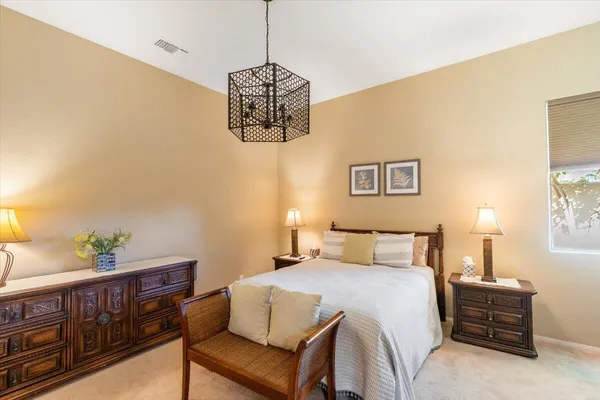 a bedroom with a bed and a chandelier