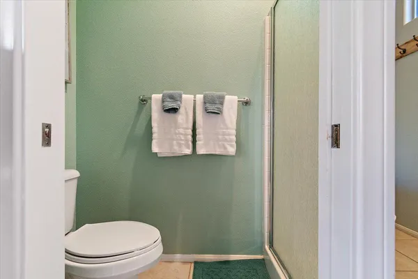 a white toilet sitting next to a shower