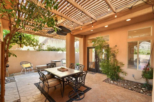 a patio with table and chairs and potted plants