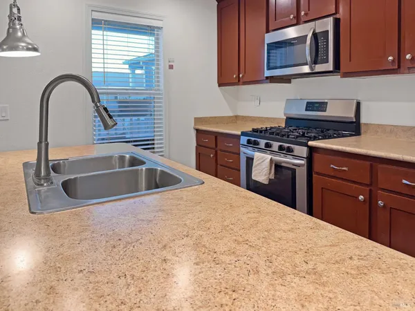 a kitchen with stainless steel appliances granite countertop a sink a stove a microwave and cabinets
