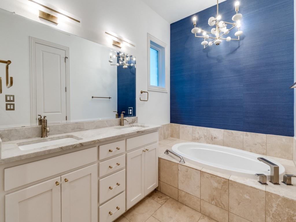 2811 Hood Street, Unit B Dallas, TX 75219 - Photo 19 of 30 a bathroom with a granite countertop double vanity sink a mirror and a bathtub