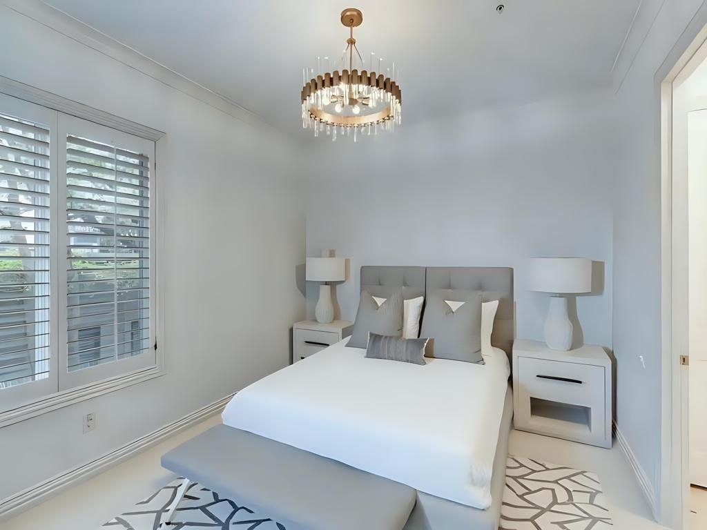 2811 Hood Street, Unit B Dallas, TX 75219 - Photo 22 of 30 a bedroom with a bed and a chandelier