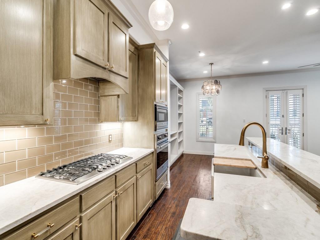 2811 Hood Street, Unit B Dallas, TX 75219 - Photo 8 of 30 a kitchen with stainless steel appliances kitchen island a sink stove and cabinets
