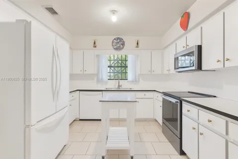a kitchen with stainless steel appliances granite countertop a sink and a stove