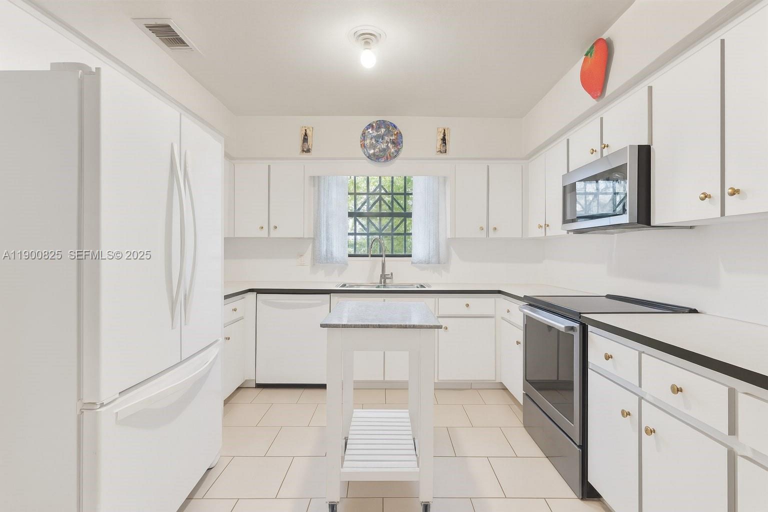7800 Southwest 95th Street Miami, FL 33156 - Photo 3 of 17 a kitchen with stainless steel appliances granite countertop a sink and a stove