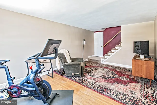 a room with gym equipment and wooden floor