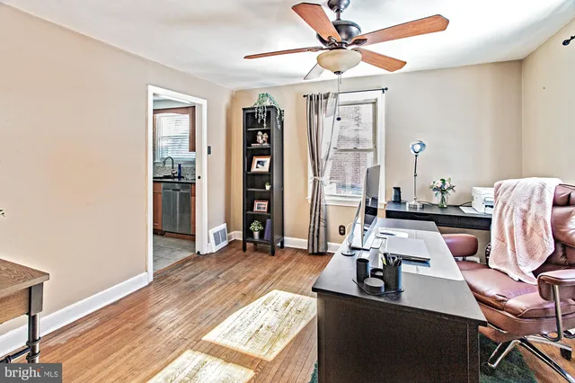 a view of a workspace with furniture and a window