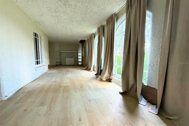 an empty room with wooden floor and a window