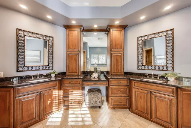 a bathroom with double vanity sinks a mirror and a bathtub
