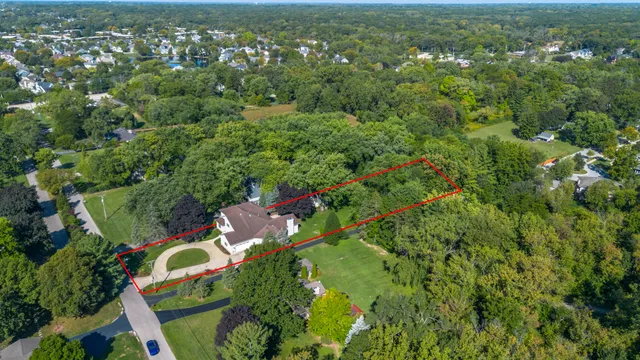 an aerial view of residential houses with outdoor space and trees