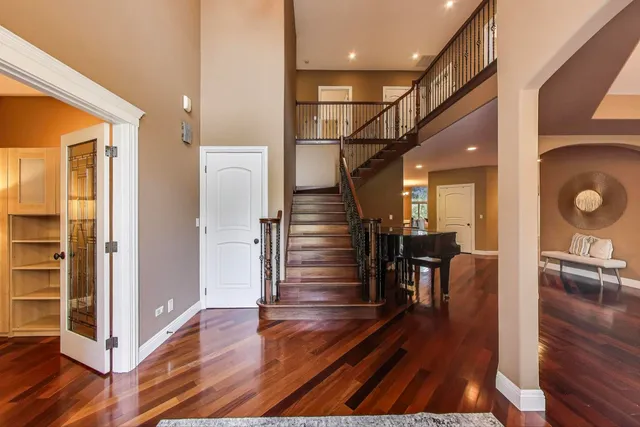 a view of a hallway with wooden floor and staircase