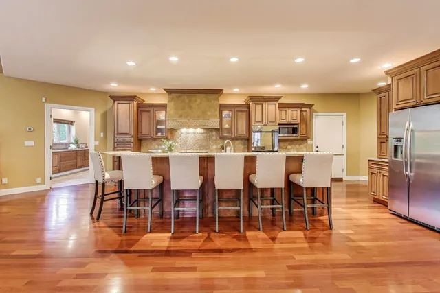 a view of a dining room with furniture wooden floor and a kitchen view