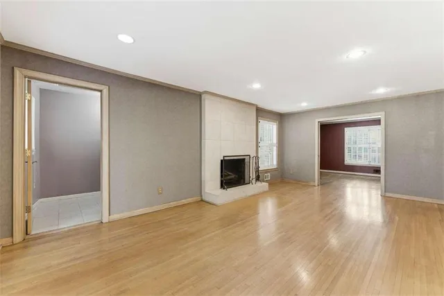 an empty room with wooden floor and fireplace