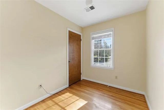 a view of an empty room with wooden floor