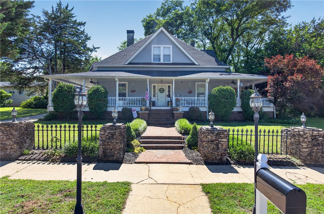 110 South Fairplay Street Seneca, SC 29678 - Photo 1 of 50 A charming Southern-style home boasts a welcoming front porch with white railings and mature landscaping.