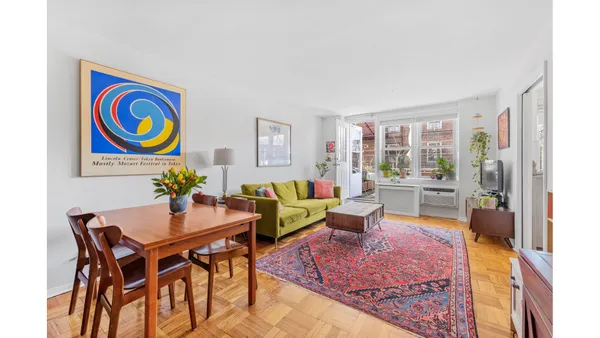 a living room with furniture and a painting on the wall