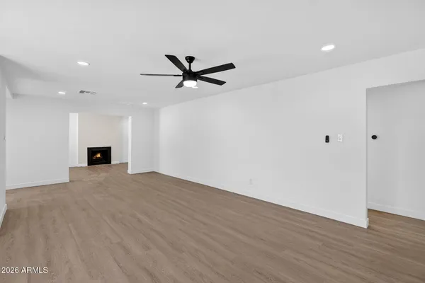 a view of a big room with wooden floor and a ceiling fan