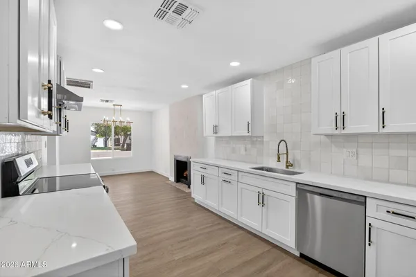a large kitchen with stainless steel appliances granite countertop a sink and cabinets