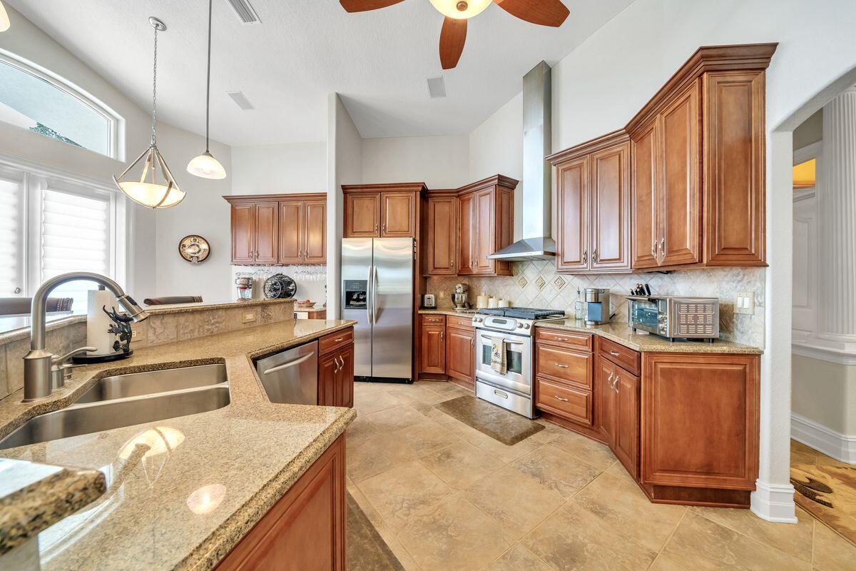 245 Country Club Road Shalimar, FL 32579 - Photo 19 of 46 a kitchen with stainless steel appliances granite countertop a sink a stove and a refrigerator