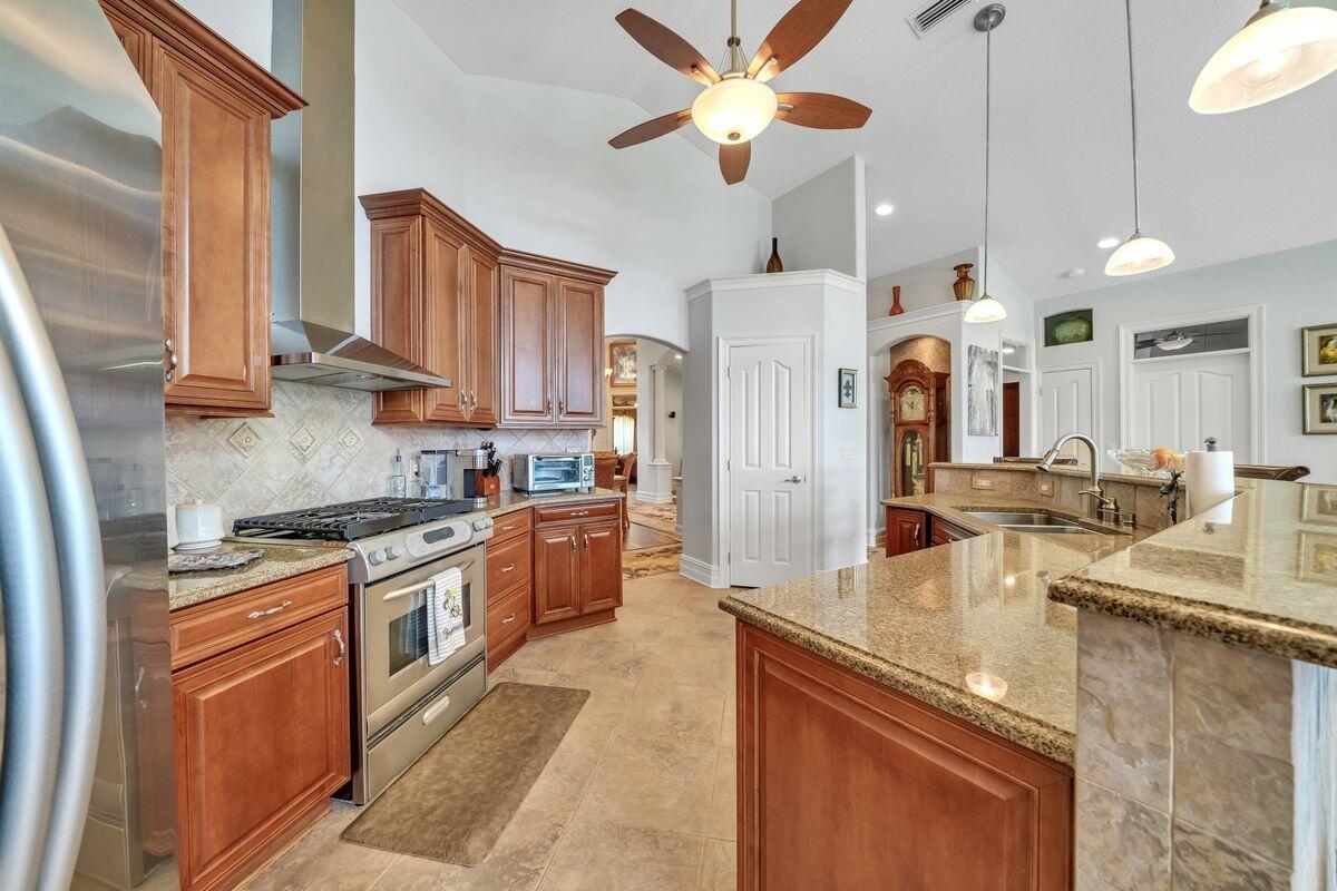 245 Country Club Road Shalimar, FL 32579 - Photo 20 of 46 a kitchen with stainless steel appliances granite countertop a sink a stove and a refrigerator