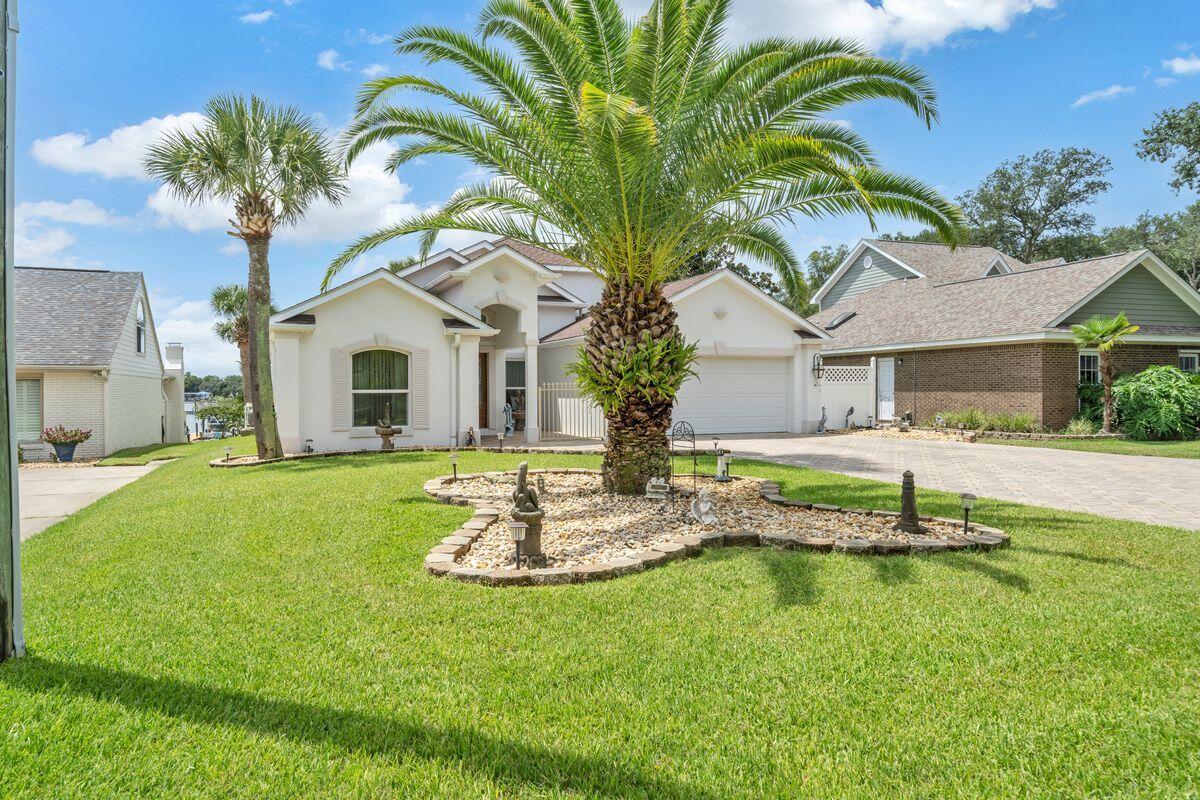245 Country Club Road Shalimar, FL 32579 - Photo 2 of 46 a house with palm tree in front of it