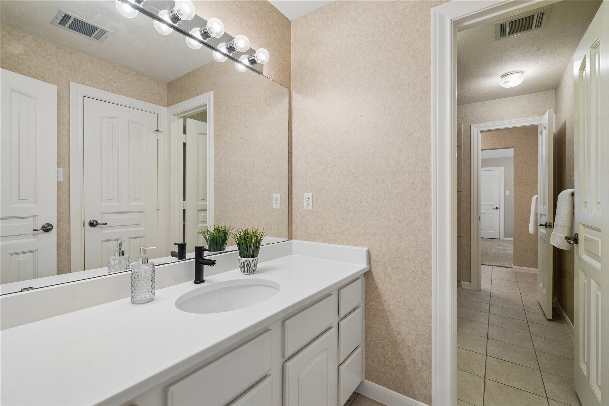 14530 Millhouse Road Pinehurst, TX 77362 - Photo 27 of 46 Hollywood style bathroom with separate private vanities featuring a shared tub/shower and toilet areas for adjoining bedrooms.