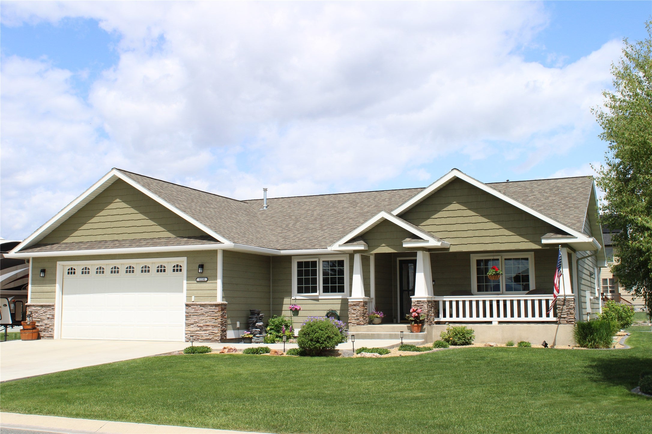 1230 Lucchese Road Helena, MT 59602 - Photo 1 of 1 Craftsman-style home with covered porch, a shingled roof, concrete driveway, a garage, and a front yard