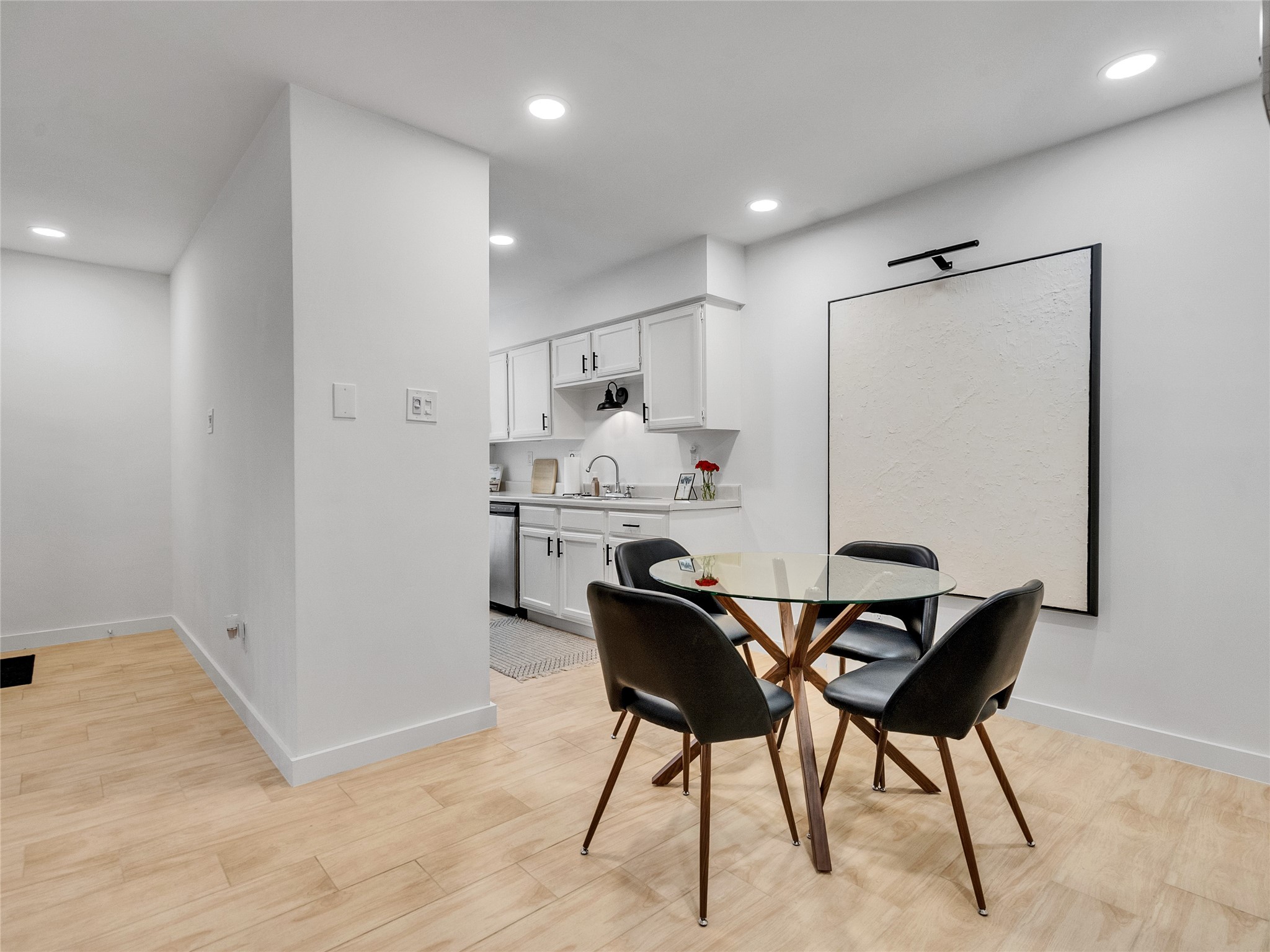 4200 Watson Street, Unit 201 Houston, TX 77009 - Photo 6 of 21 a kitchen with kitchen island a dining table chairs cabinets and stainless steel appliances