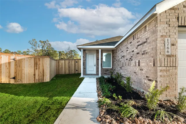 a view of backyard with potted plants and wooden fence