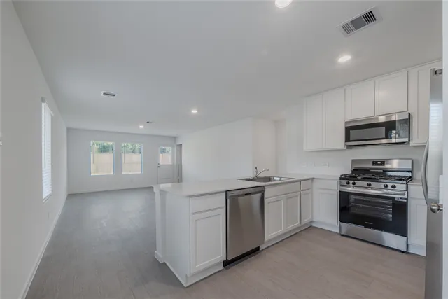 a kitchen with stainless steel appliances granite countertop a stove and a sink