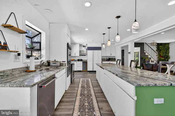 a large kitchen with kitchen island a large counter space a sink appliances and cabinets