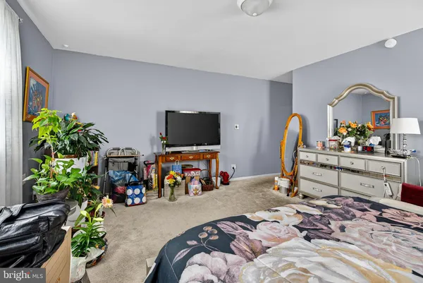 a bedroom with bed and a flat screen tv