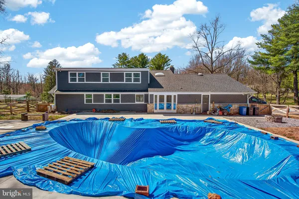 a front view of a house with swimming pool having outdoor seating
