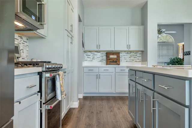 a kitchen with cabinets appliances and a wooden floor