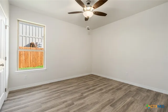 wooden floor in an empty room with a window