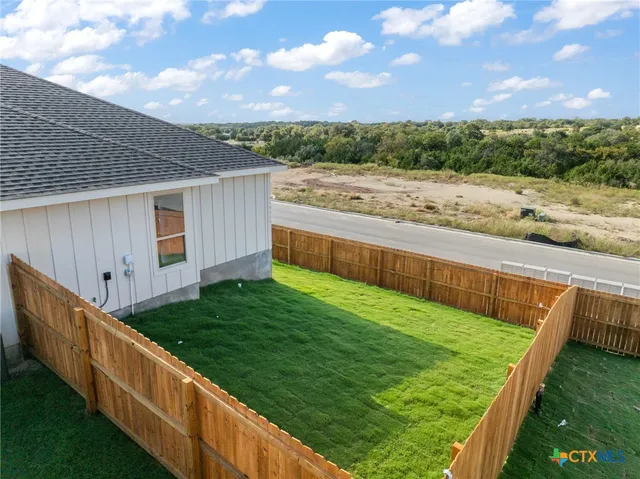 a view of a backyard with wooden fence