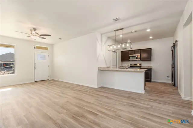 a view of kitchen with sink microwave and refrigerator
