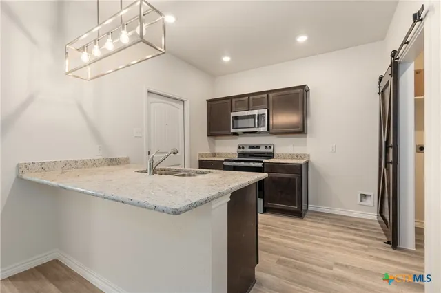 a kitchen with stainless steel appliances granite countertop a sink stove and refrigerator