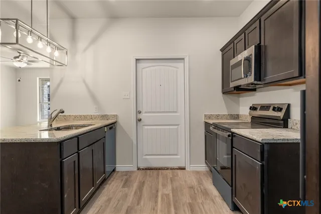a kitchen with stainless steel appliances granite countertop a sink stove and refrigerator