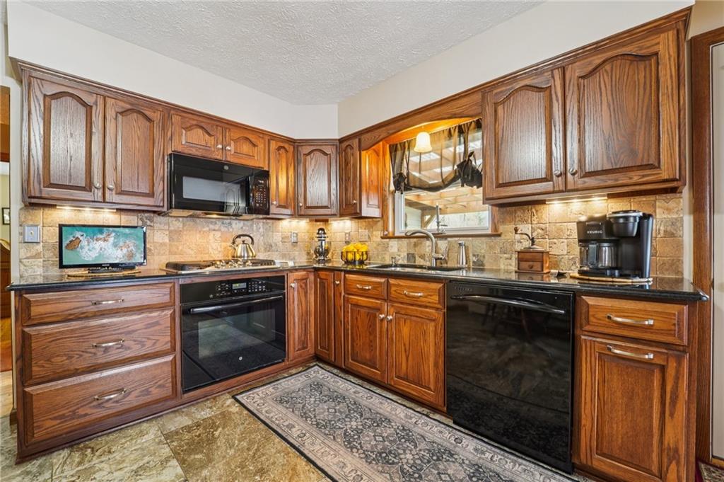 2691 Harlansburg Road New Castle, PA 16101 - Photo 11 of 42 a kitchen with stainless steel appliances granite countertop a stove sink microwave and window