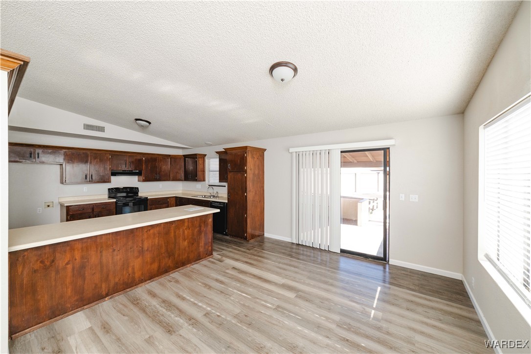 2063 East Sundown Road Kingman, AZ 86409 - Photo 14 of 40 Kitchen with light countertops, a sink, a peninsula, visible vents, and black appliances