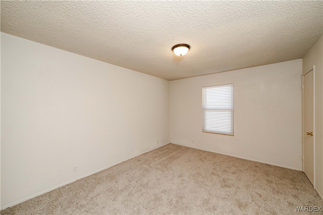 2063 East Sundown Road Kingman, AZ 86409 - Photo 17 of 40 Carpeted spare room featuring a textured ceiling