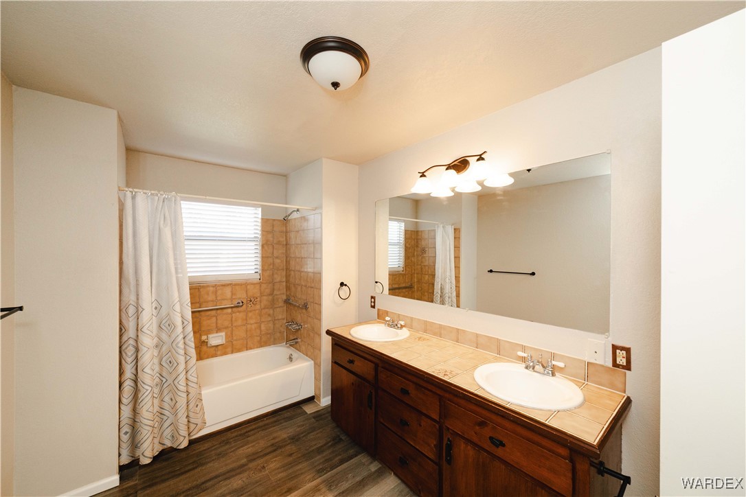 2063 East Sundown Road Kingman, AZ 86409 - Photo 18 of 40 Bathroom with double vanity, a sink, shower / bath combo, and wood finished floors