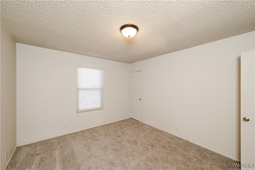 2063 East Sundown Road Kingman, AZ 86409 - Photo 20 of 40 Carpeted spare room with a textured ceiling