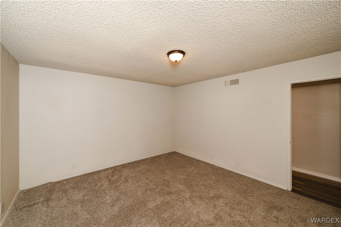 2063 East Sundown Road Kingman, AZ 86409 - Photo 24 of 40 Carpeted spare room with a textured ceiling and visible vents